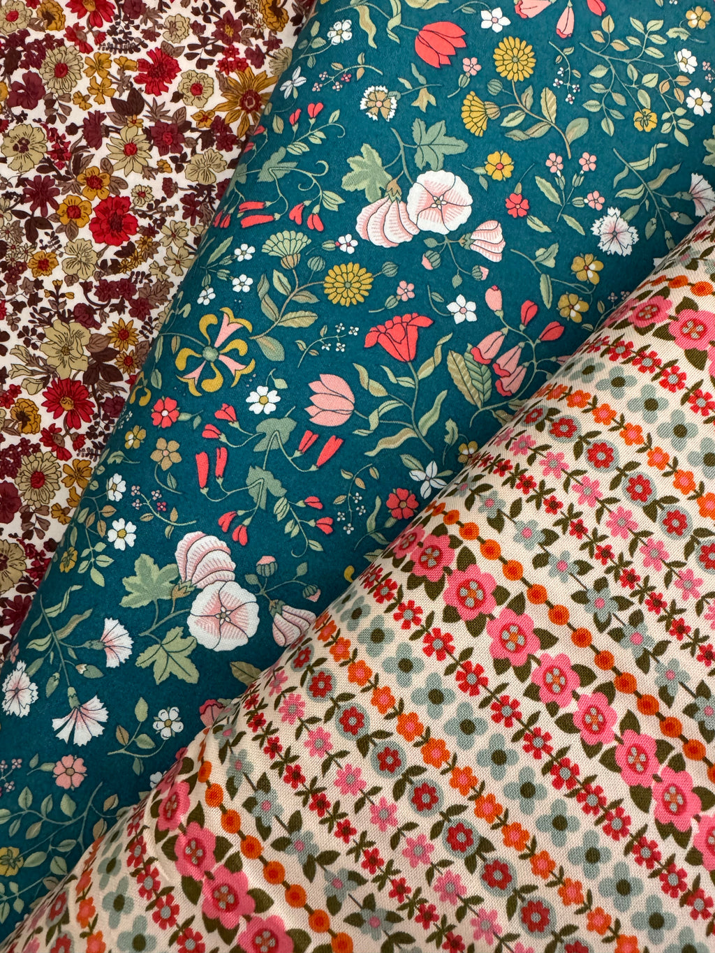 Collection of floral fabric swatches in various colors and patterns.