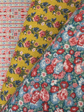 Close-up of floral fabric with red, pink, and blue flowers on a yellow background.