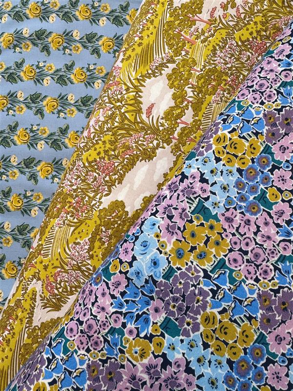 Colorful floral patterned fabric with a mix of blue, yellow, and purple flowers.
