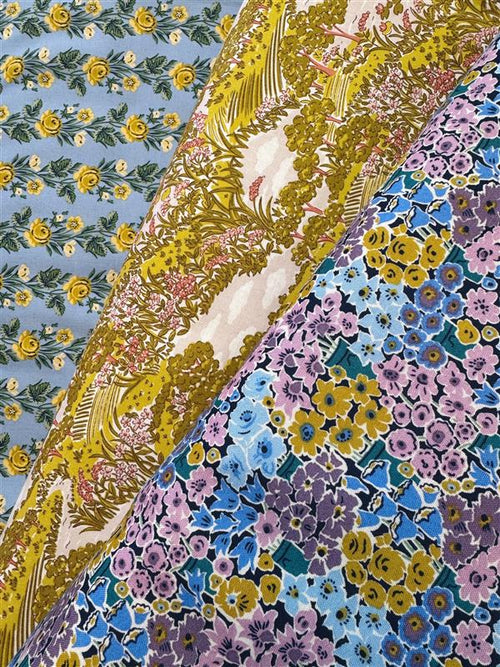 Colorful floral patterned fabric with a mix of blue, yellow, and purple flowers.