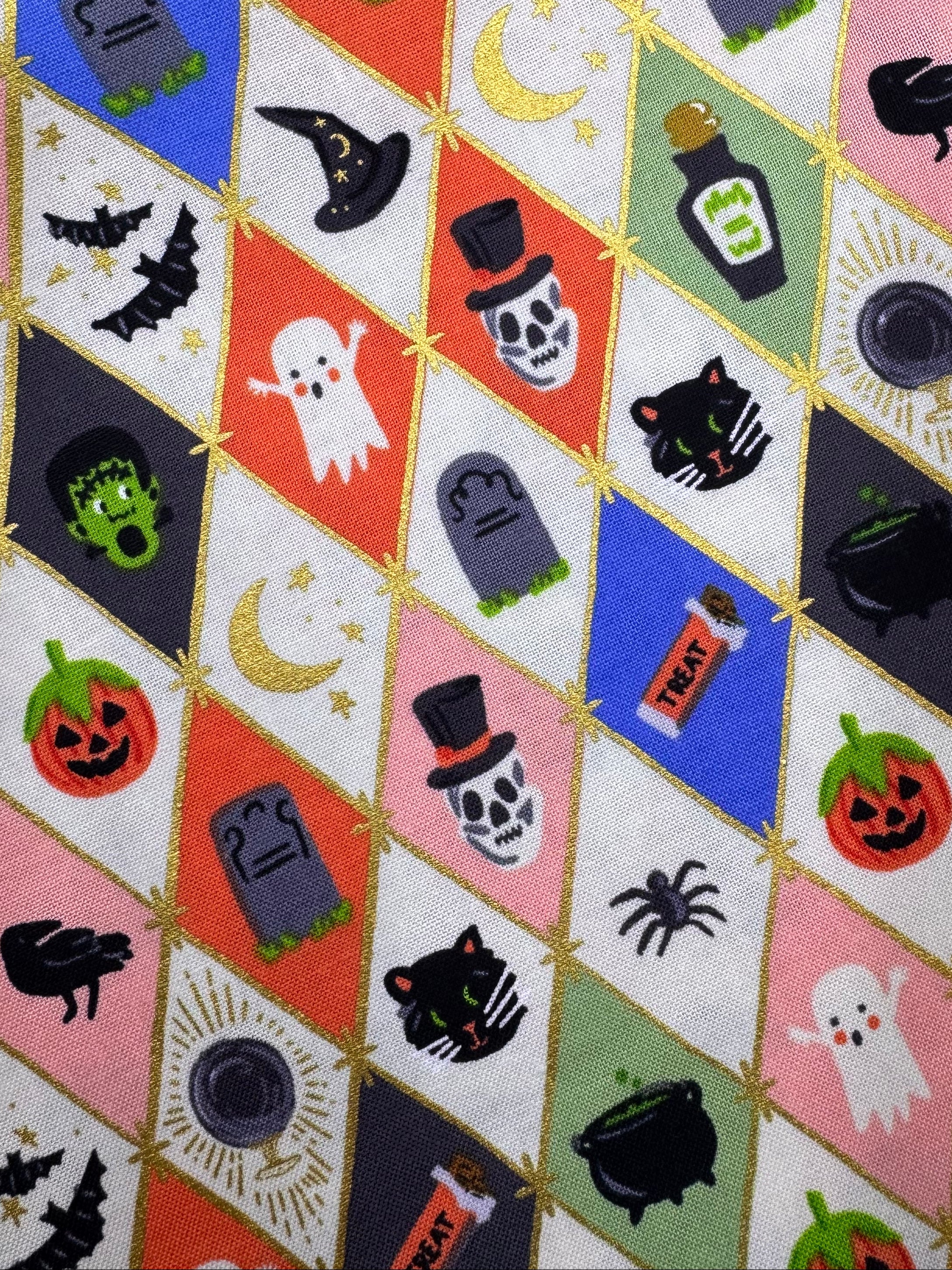 Halloween-themed fabric with various icons on a wooden surface