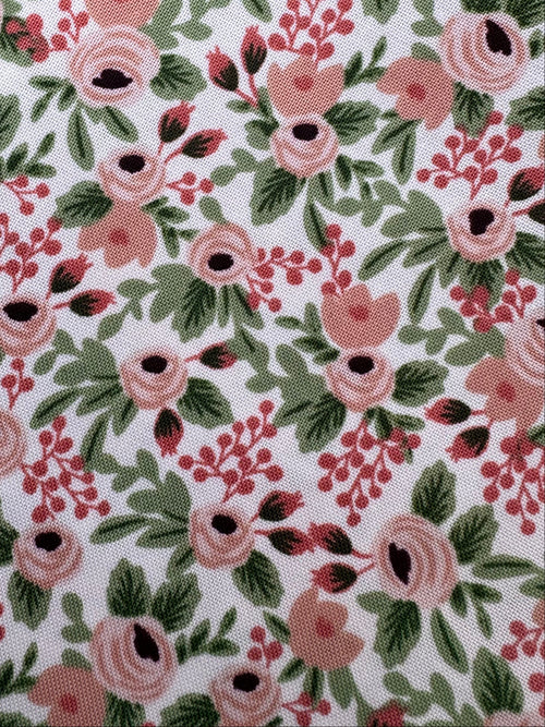 Floral fabric with pink and green pattern on a wooden surface