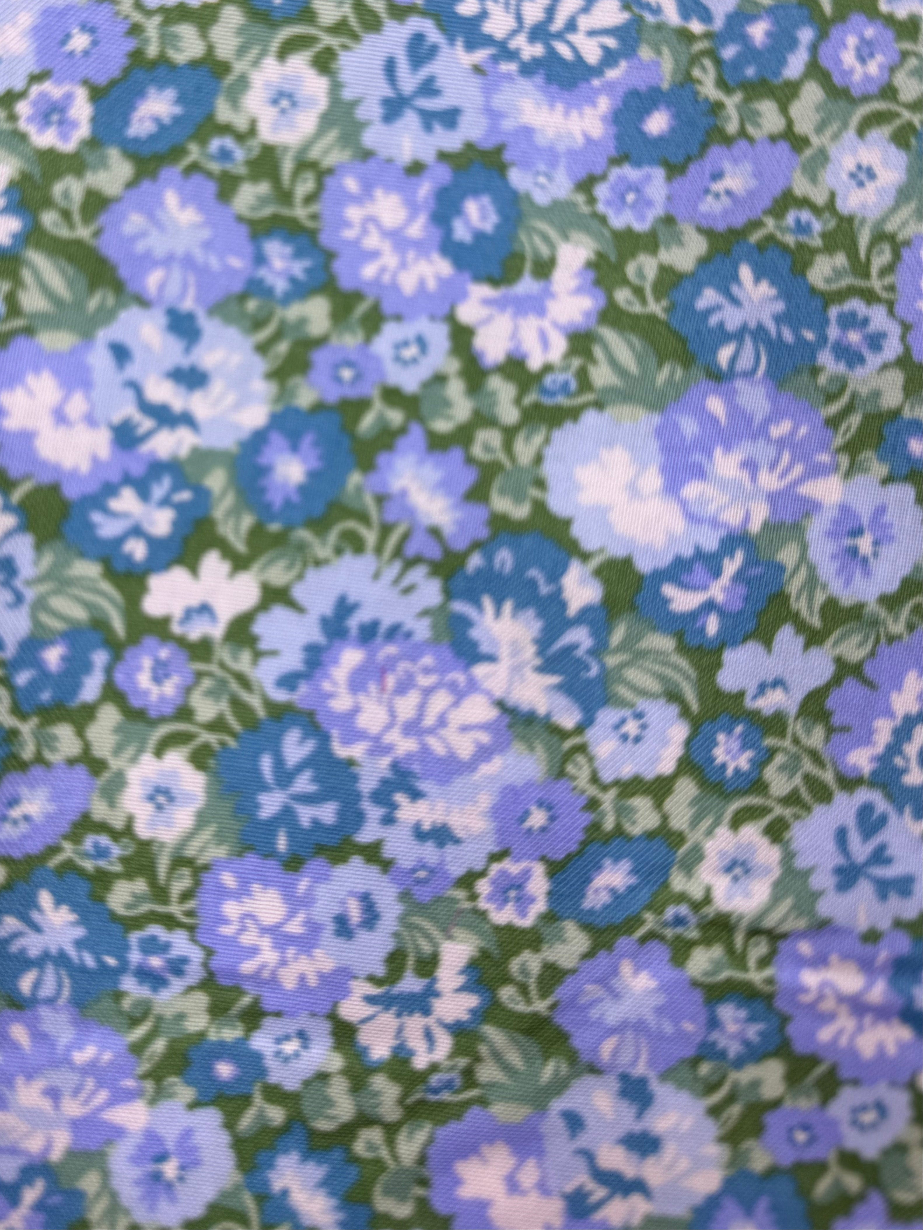 Floral fabric with blue and green pattern on a wooden surface