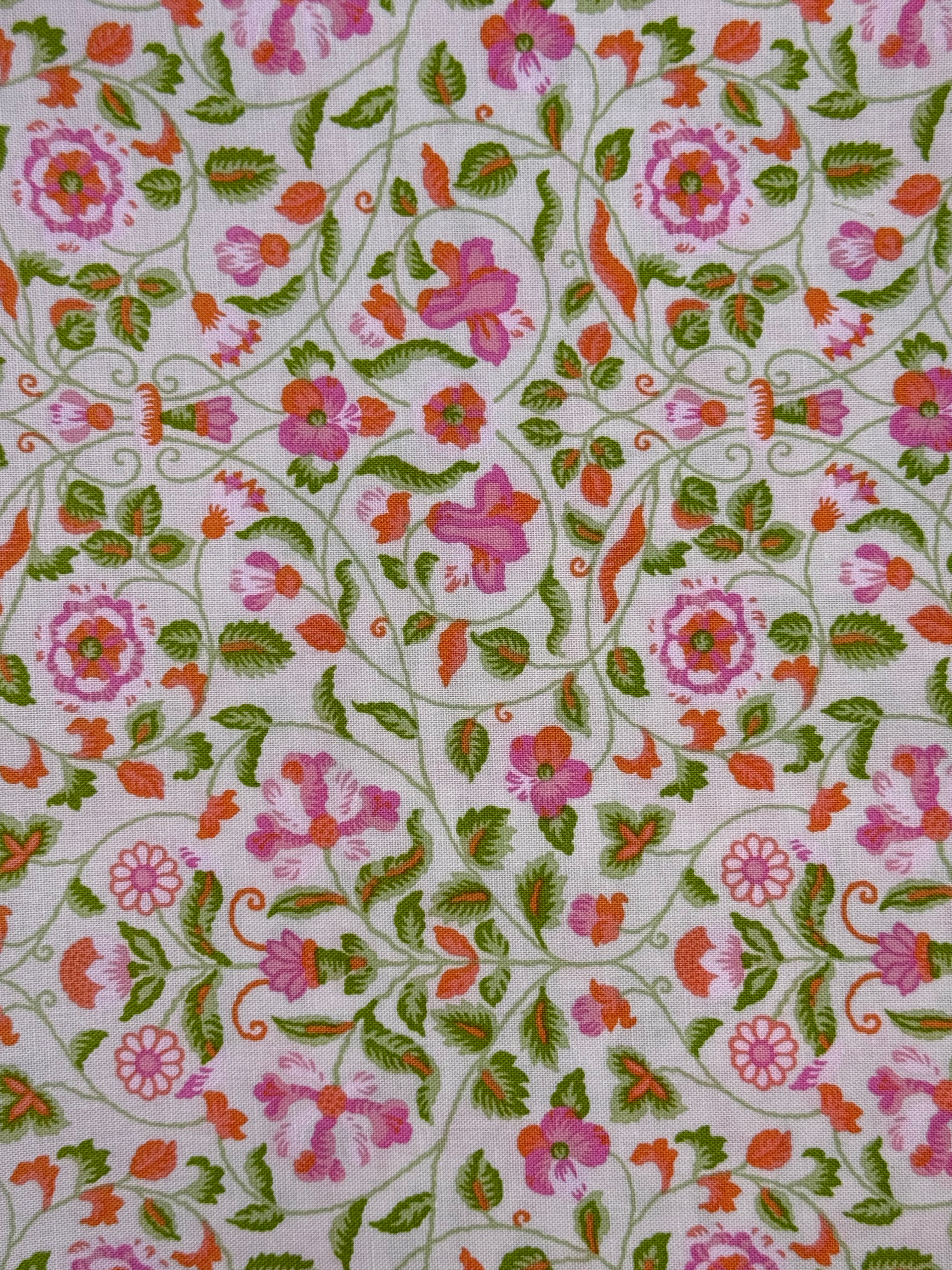 Floral patterned fabric with pink, green, and orange flowers on a white background