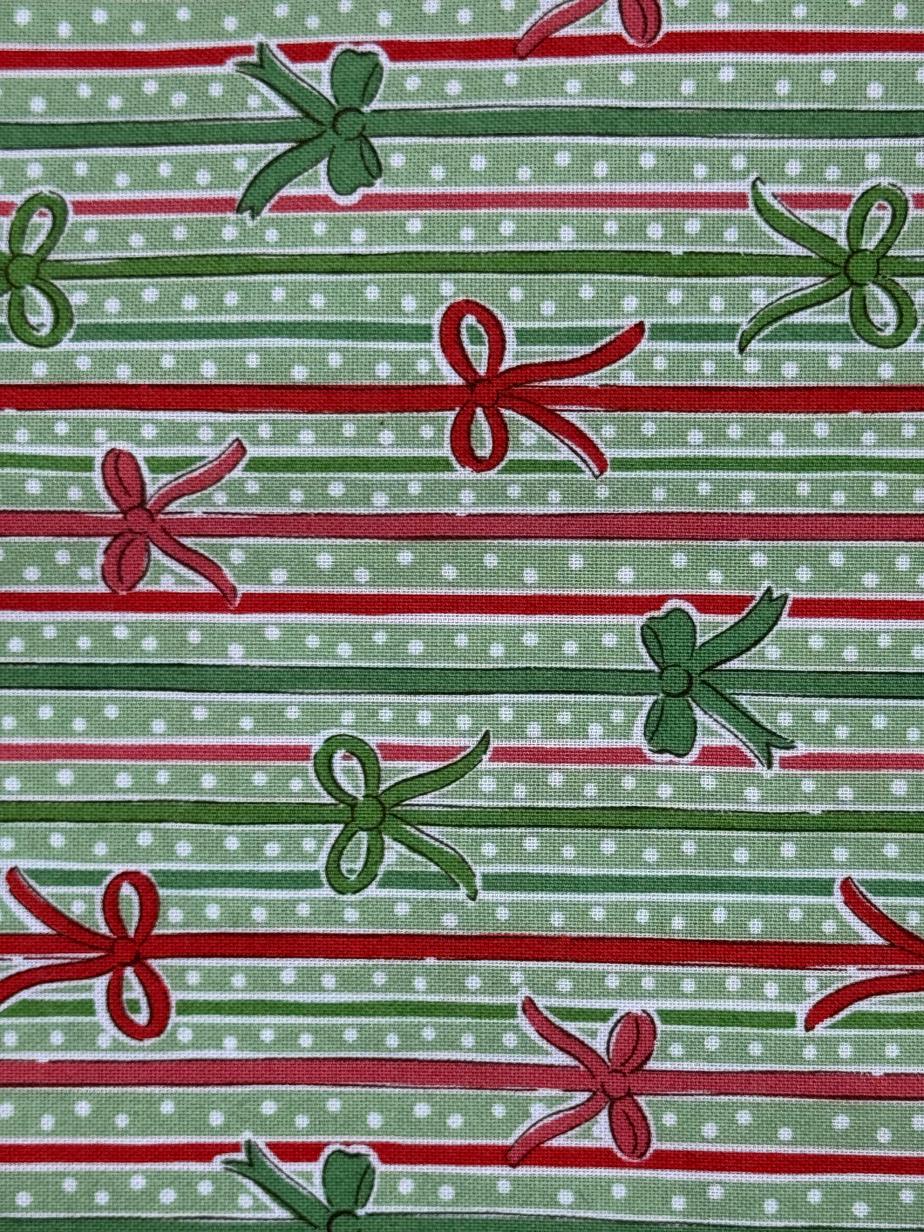 A close-up of a repeating holiday pattern featuring green and red gift bows and horizontal stripes on a light green polka-dot background.