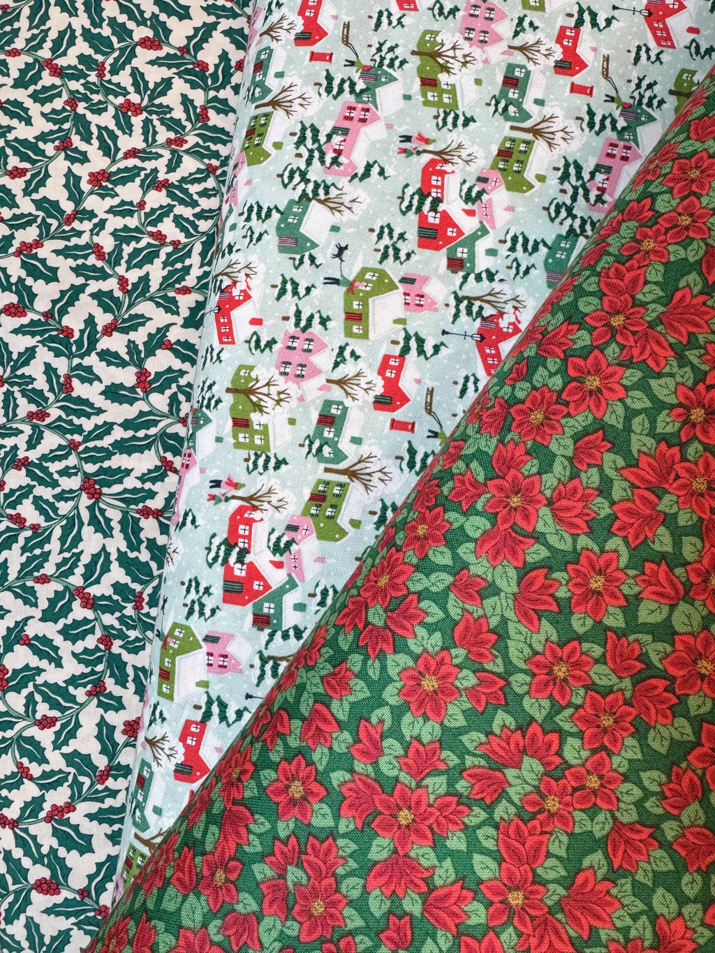 Three different Christmas-themed fabric patterns with holly, stockings, and poinsettias.