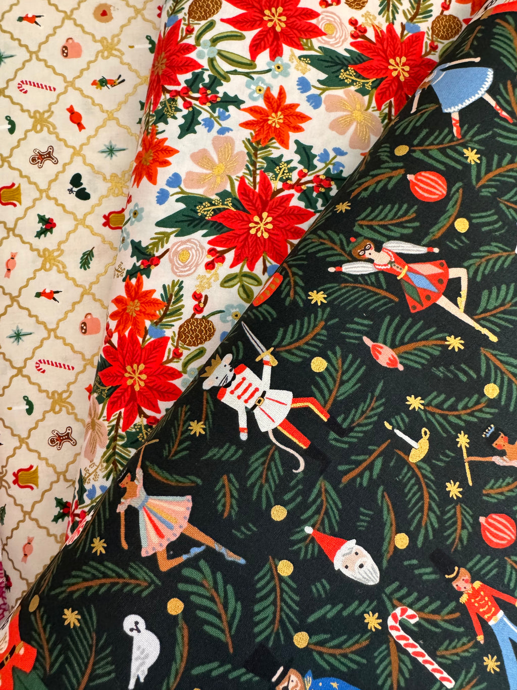 Three fabric swatches with festive patterns including poinsettias and holiday-themed designs.