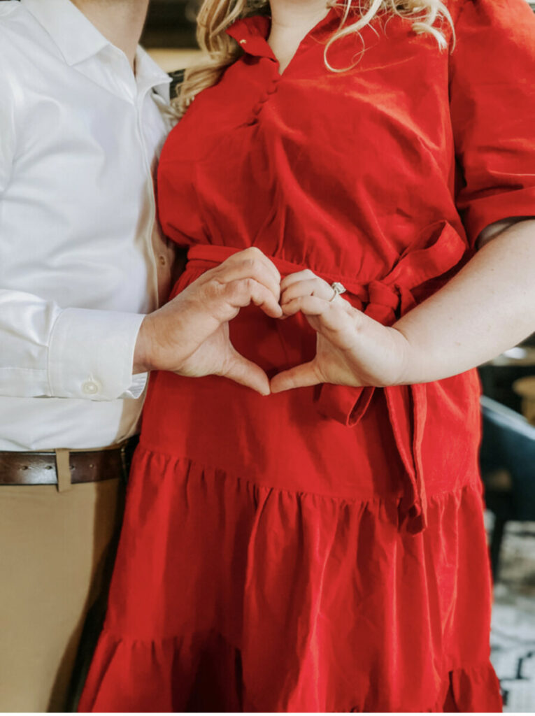 Couple making heart over pregnant baby belly